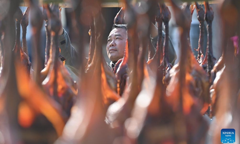 A villager dries cured ducks in Ma'an Village of Luzhai County, south China's Guangxi Zhuang Autonomous Region, Dec. 26, 2023. The alluring aroma of cured meat has wafted out as winter comes.(Photo: Xinhua)