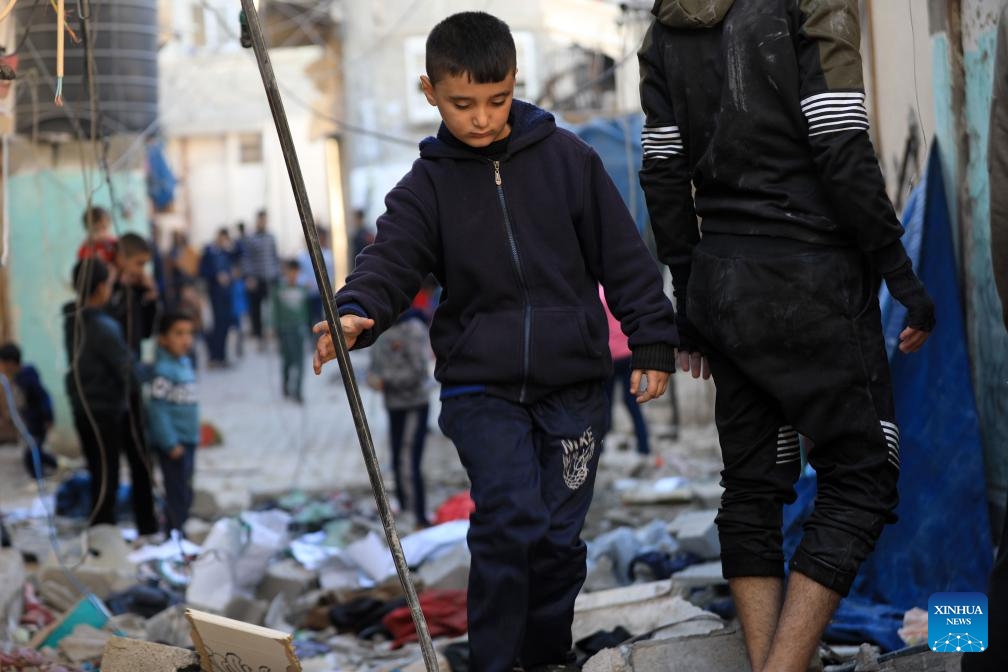 A boy walks among the rubble after an Israeli airstrike in the southern Gaza Strip city of Rafah, on Dec. 26, 2023. At least 20,915 Palestinians have been killed, and 54,918 others wounded in the Israel-Hamas conflict since Oct. 7, the Gaza-based Health Ministry said Tuesday.(Photo: Xinhua)
