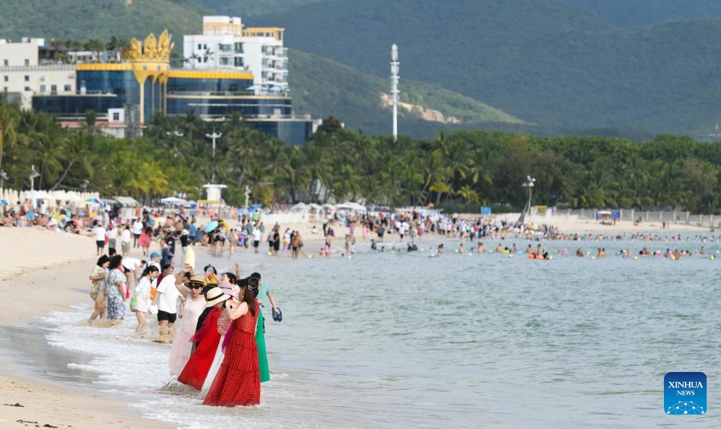 Tourists have fun at Dadonghai scenic area in Sanya, south China's Hainan Province, Dec. 15, 2023. Since the beginning of winter, the tourism market in Sanya has been heating up continuously. According to official data, the city witnessed a peak season for tourism since mid-November, which is expected to last until the Spring Festival.(Photo: Xinhua)
