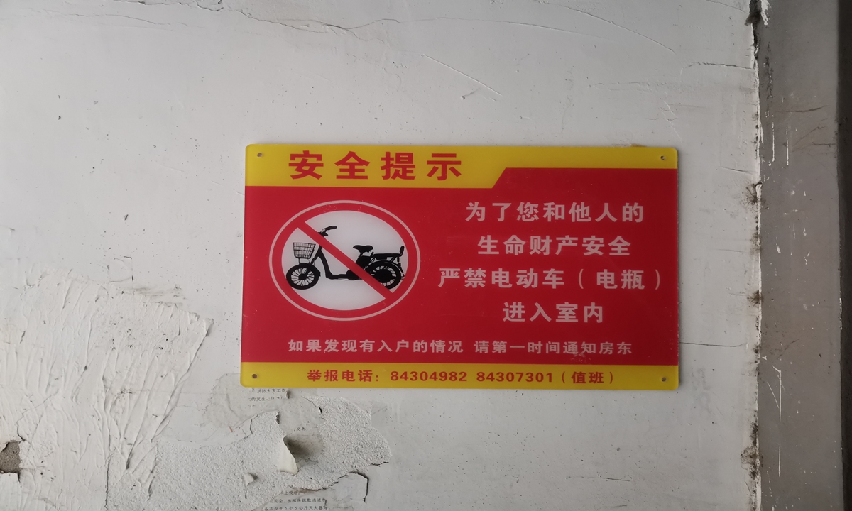 The safety notice on the wall says Parking of electric bikes indoors not allowed, in Dongxindian village, Beijing. Photo: VCG