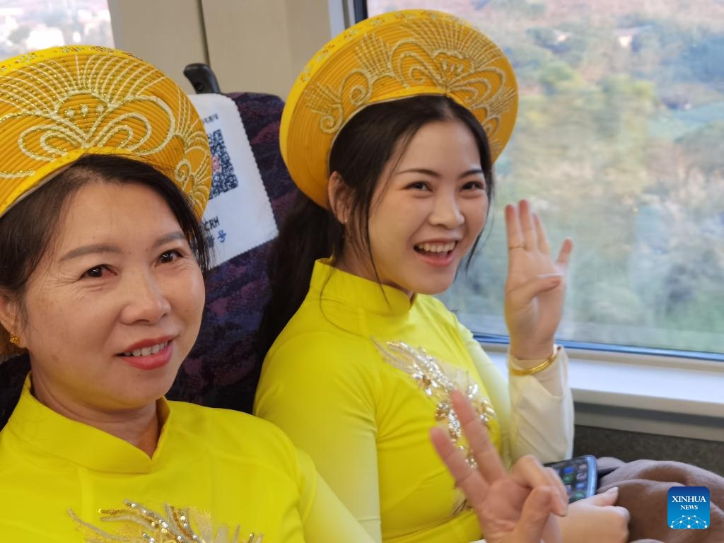 Passengers in traditional costumes are seen on a bullet train running on the newly-opened railway linking Dongxing and Fangchenggang in south China's Guangxi Zhuang Autonomous Region on Dec. 27, 2023. Dongxing, a city on the China-Vietnam border in south China's Guangxi Zhuang Autonomous Region, was linked to China's national railway network on Wednesday with the opening of a new rail line.(Photo: Xinhua)