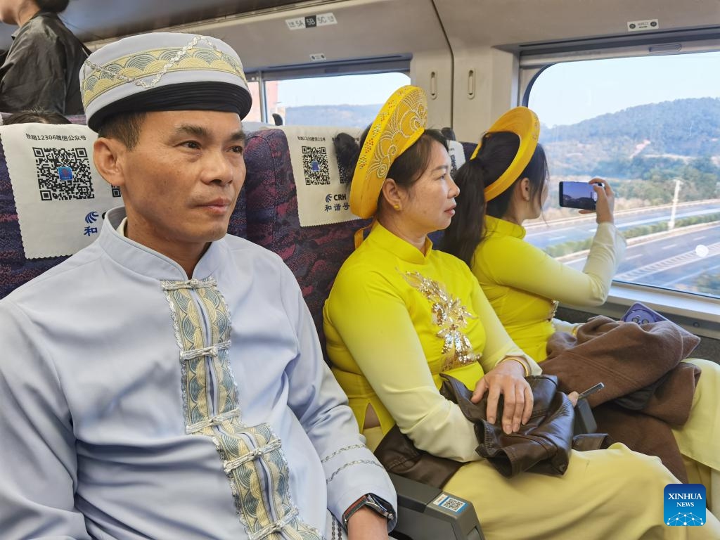 Passengers in traditional costumes are seen on a bullet train running on the newly-opened railway linking Dongxing and Fangchenggang in south China's Guangxi Zhuang Autonomous Region on Dec. 27, 2023. Dongxing, a city on the China-Vietnam border in south China's Guangxi Zhuang Autonomous Region, was linked to China's national railway network on Wednesday with the opening of a new rail line.(Photo: Xinhua)
