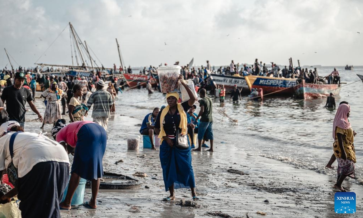 A woman sells snacks at a fishing port in Dar es Salaam, Tanzania on Dec. 28, 2023. (Photo: Xinhua)