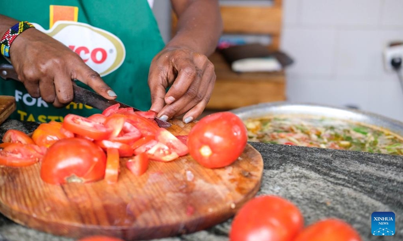 Dorcus Bashema Kirabo prepares a meal as she is set to break the Guinness world record for the longest cooking time by an individual in Kampala, the capital of Uganda, on Dec. 26, 2023. (Photo: Xinhua)