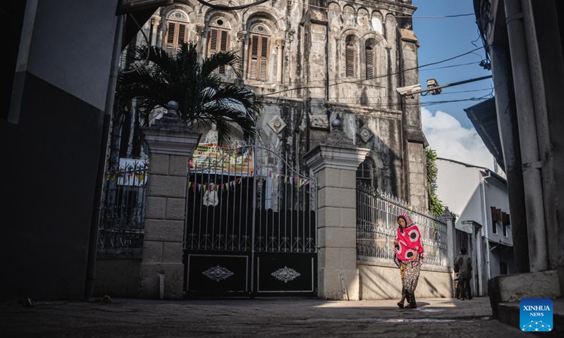 A woman walks past a church in the Stone Town of Zanzibar, Tanzania, Dec. 30, 2023. Zanzibar consists of two large coral islands - Zanzibar and Pemba, and more than 20 adjacent islets. For nearly 10 centuries, Zanzibar has blended the diverse cultures of Africa, Asia and Europe, becoming an important cultural attraction and holiday destination in East Africa. (Photo: Xinhua)