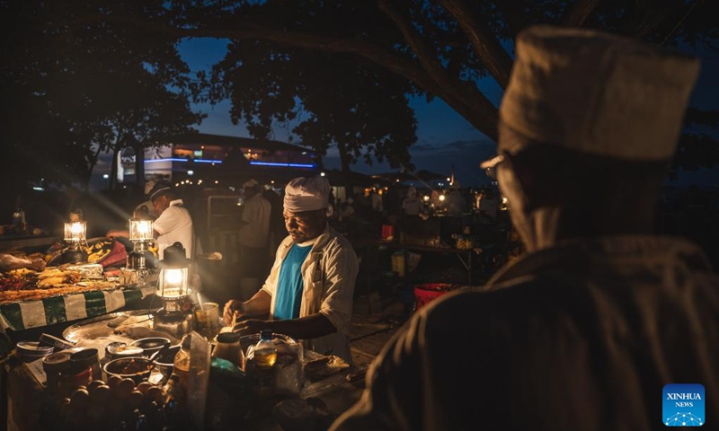 Vendors sell food at a night market in Zanzibar, Tanzania, Dec. 31, 2023. Zanzibar consists of two large coral islands - Zanzibar and Pemba, and more than 20 adjacent islets. For nearly 10 centuries, Zanzibar has blended the diverse cultures of Africa, Asia and Europe, becoming an important cultural attraction and holiday destination in East Africa. (Photo: Xinhua)