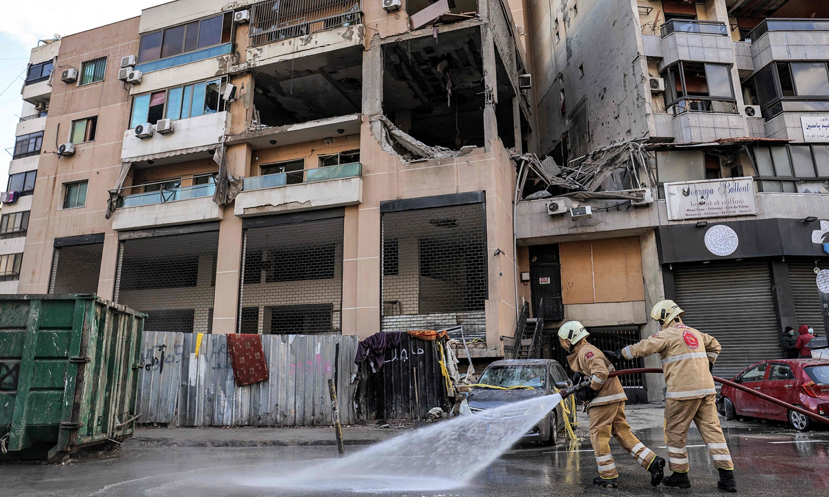 Lebanese civil defense members spray water on the street by the building that was hit by an Israeli strike targeting Hamas deputy leader Saleh al-Aruri in the southern suburb of Beirut on January 3, 2024. Aruri was killed on January 2 along with his bodyguards in a strike by Israel, which has vowed to destroy Hamas after the movement's shock October 7 attacks. Photo: VCG