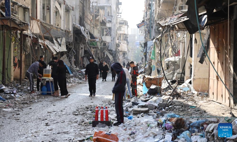 People are seen on a street with damaged buildings in Gaza City, on Jan. 2, 2024. The death toll of Palestinians has exceeded 22,000 after the outbreak of the Israel-Hamas conflict on Oct. 7, 2023, the Hamas-run Health Ministry said on Tuesday.(Photo: Xinhua)