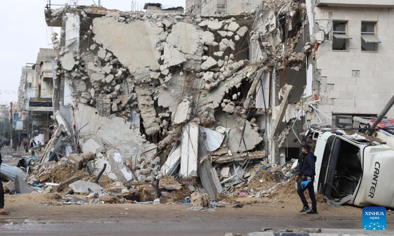 A man walks past a destroyed building in Gaza City, on Jan. 2, 2024. The death toll of Palestinians has exceeded 22,000 after the outbreak of the Israel-Hamas conflict on Oct. 7, 2023, the Hamas-run Health Ministry said on Tuesday. (Photo: Xinhua)