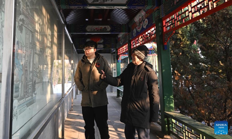 Xi Wang (L) and his mentor Wang Wenda watch new year pictures on the wall at Yangliuqing Town in Tianjin, north China, Dec. 27, 2023. (Photo: Xinhua)