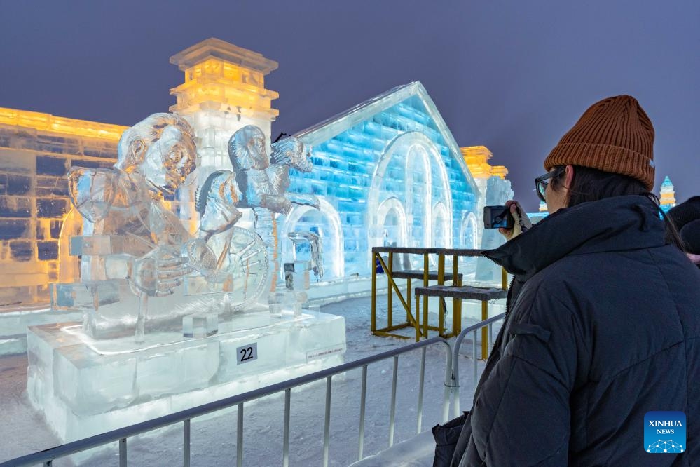 A visitor takes photos of ice sculptures at Harbin Ice-Snow World in Harbin, northeast China's Heilongjiang Province, Jan. 4, 2024. The 35th Harbin International Ice Sculpture Competition concluded here on Thursday.(Photo: Xinhua)