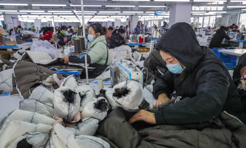 Workers make down jackets at a workshop in Guangshan county, Central China's Henan Province, on January 11, 2024. Guangshan county, a major down clothing processing base, sells its down jackets to more than 100 countries and regions around the world through e-commerce, with an annual output value of nearly 7 billion yuan ($978 million). Photo: VCG