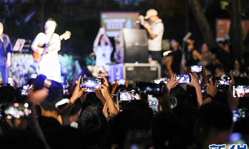 People take photos at a roadside concert at Wenchang Pavillion in Guiyang. Photo: Xinhua