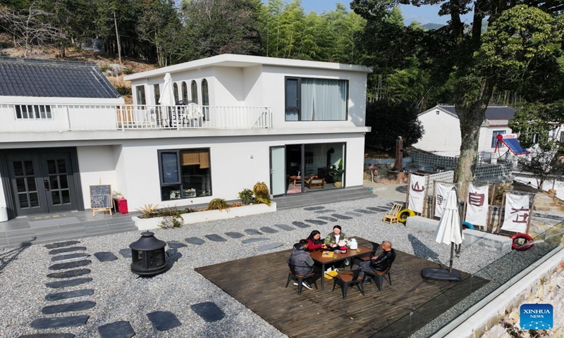 This aerial photo taken on Jan. 6, 2024 shows tourists chatting at a homestay in Tianzhu Village of Shuihou Township, Qianshan City, east China's Anhui Province. The tourist service of Shuihou Township at the foot of Tianzhu Mountain used to be limited to pure sightseeing in the mountainous areas. (Xinhua/Du Yu)