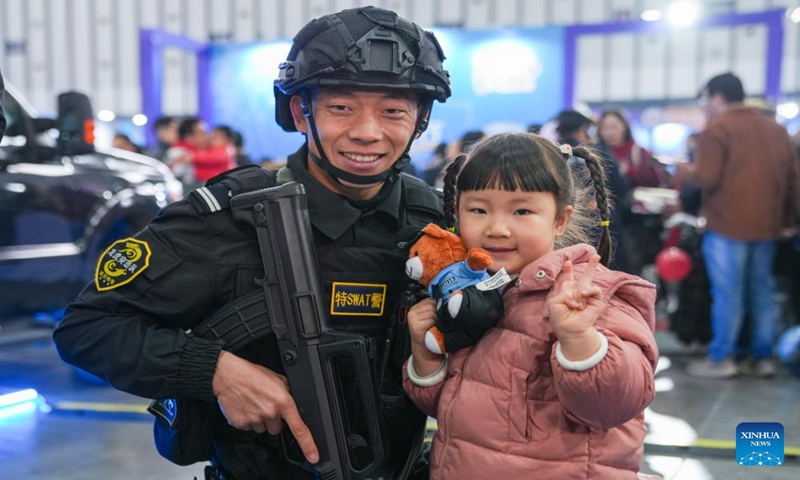 A young visitor poses with a SWAT member for a photo during a police open week event in Nanjing, east China's Jiangsu Province, Jan. 6, 2024. (Xinhua/Li Bo)