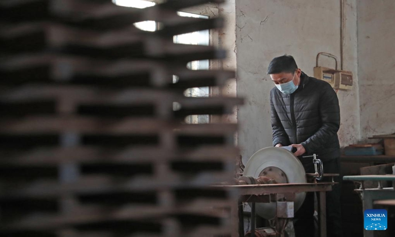 Gong Zhiguang grinds a block for erhu making in Changtu County of Tieling City, northeast China's Liaoning Province, Dec. 28, 2023. (Xinhua/Yang Qing)
