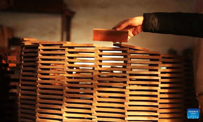 Gong Zhiguang picks a block for erhu making in Changtu County of Tieling City, northeast China's Liaoning Province, Dec. 28, 2023. (Xinhua/Yang Qing)