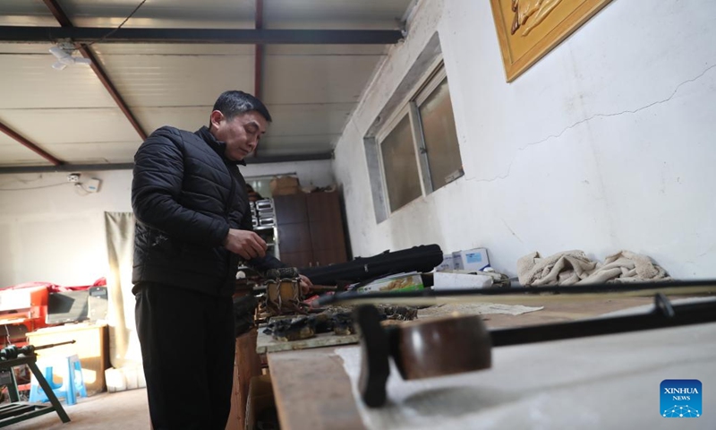 Gong Zhiguang seals an erhu with leather in Changtu County of Tieling City, northeast China's Liaoning Province, Dec. 28, 2023. (Xinhua/Yang Qing)