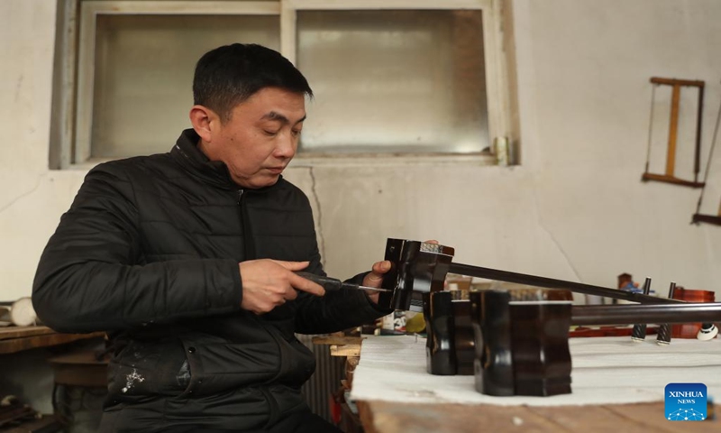 Gong Zhiguang assembles an erhu in Changtu County of Tieling City, northeast China's Liaoning Province, Dec. 28, 2023. (Xinhua/Yang Qing)