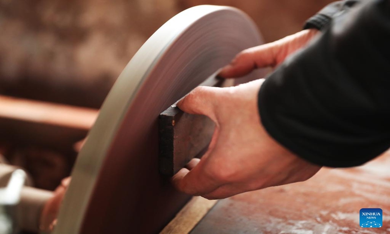 Gong Zhiguang seals an erhu with leather in Changtu County of Tieling City, northeast China's Liaoning Province, Dec. 28, 2023. (Xinhua/Yang Qing)