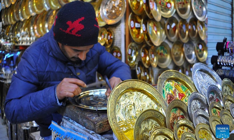 A craftsman carves patterns on a metalware in the Medina of Tunis, Tunisia on Jan. 9, 2024. Engraved metal objects are the main tourist souvenirs in Tunisia. The arts, skills and practices associated with engraving on metals, such as gold, silver and copper, which are widely spread in Arab countries, were inscribed in 2023 on the Representative List of the Intangible Cultural Heritage of Humanity.(Photo: Xinhua)