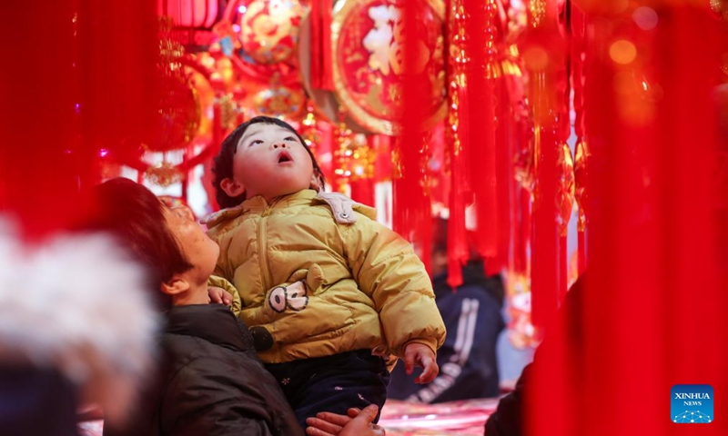 People select decortations for Spring Festival at a market in Yangzhou, east China's Jiangsu Province, Jan. 13, 2024. China's 2024 Spring Festival holiday will run from Feb. 10 to 17. (Photo by Qi Liguang/Xinhua)