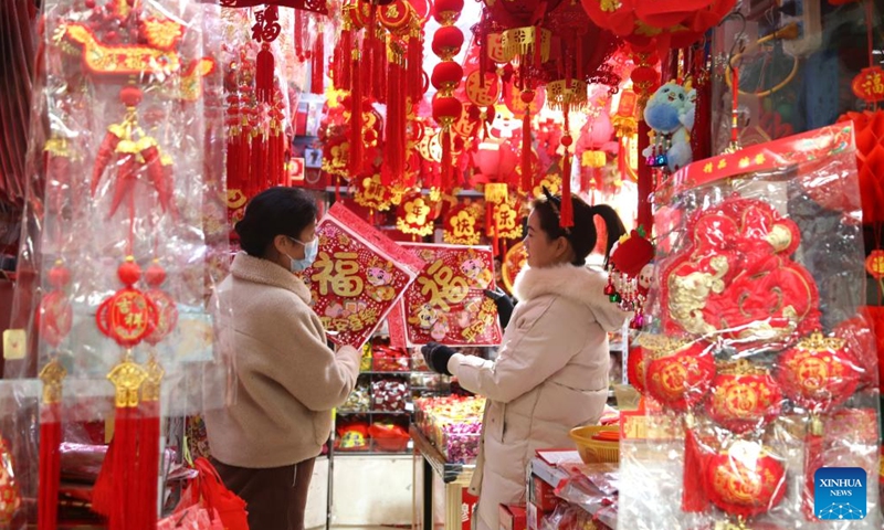 People select decortations for Spring Festival at market in Lianyungang, east China's Jiangsu Province, Jan. 13, 2024. China's 2024 Spring Festival holiday will run from Feb. 10 to 17. (Photo by Wang Chun/Xinhua)