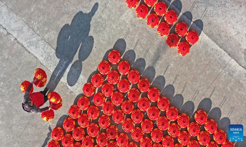 An aerial drone photo taken on Jan. 13, 2024 shows a staff member drying lanterns at a lantern factory in Hengxi township of Xianju County, Taizhou City, east China's Zhejiang Province. China's 2024 Spring Festival holiday will run from Feb. 10 to 17. (Photo by Wang Huabin/Xinhua)