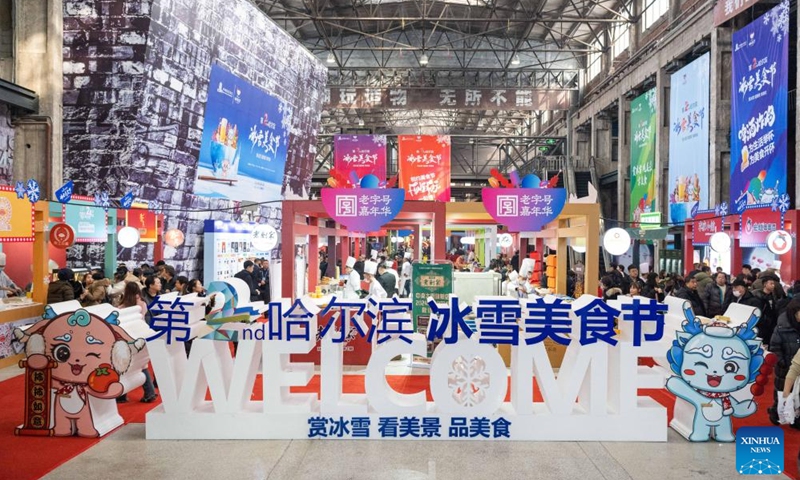 Tourists taste food during a food festival in Harbin, northeast China's Heilongjiang Province, Jan. 20, 2024. (Xinhua/Xie Jianfei)
