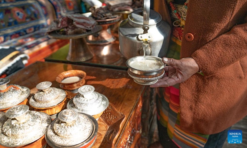 Pasang Butri pours highland barley wine during the celebration of the farmers' New Year at home in Xigaze, southwest China's Xizang Autonomous Region, Jan. 12, 2024. Locals in Xigaze celebrate the farmers' New Year on the first day of the twelfth month of the Tibetan calendar, which fell on Jan. 12 this year.