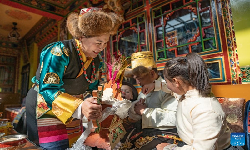 Pasang Butri's daughter Tsering Butri (1st L) prepares chema box for her family members at home in Xigaze, southwest China's Xizang Autonomous Region, Jan. 12, 2024. Locals in Xigaze celebrate the farmers' New Year on the first day of the twelfth month of the Tibetan calendar, which fell on Jan. 12 this year.