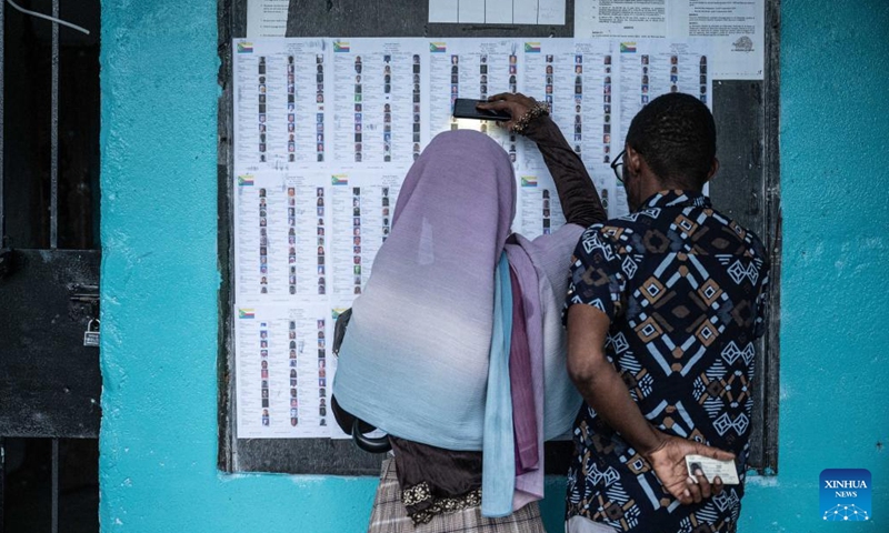 People check the information of candidates at a polling station in Mitsudje, Comoros, Jan. 14, 2024. Comoros kicked off its first round of the presidential election on Sunday to select the national leader from among six candidates, including incumbent President Azali Assoumani, for the next five years. (Xinhua/Wang Guansen)