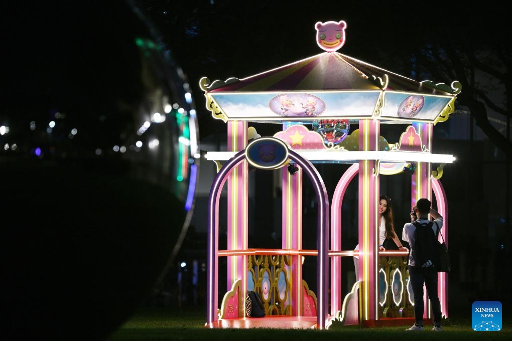 A woman poses for photos with a light installation during a media preview of the Light to Night Festival at Singapore's Civic District on Jan. 16, 2024. The Light to Night Festival will be held from Jan. 19 to Feb. 8 in various locations in the Civic District.(Photo: Xinhua)