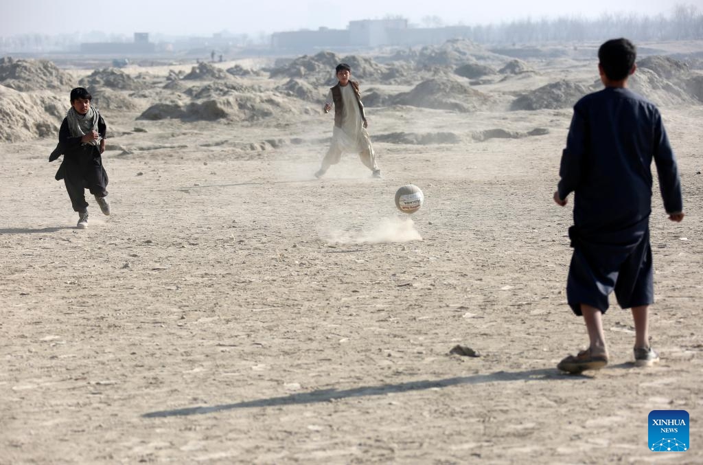 Afghan boys play football in the cold weather on a dusty ground at the Alokhil village in Kabul, capital of Afghanistan, Jan, 16, 2024.(Photo: Xinhua)