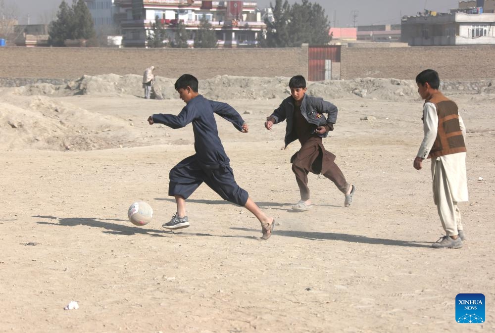 Afghan boys play football in the cold weather on a dusty ground at the Alokhil village in Kabul, capital of Afghanistan, Jan, 16, 2024.(Photo: Xinhua)