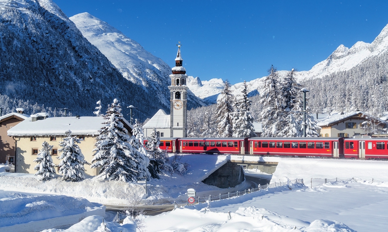 The Bernina Express travels along snowcovered mountains in Switzerland. Photo: VCG