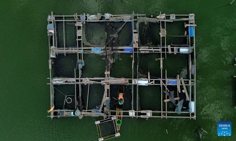 An aerial drone photo taken on Jan. 18, 2024 shows a fisherman working at a floating fish farm in Lhokseumawe, Aceh Province, Indonesia. (Photo by Fachrul Reza/Xinhua)