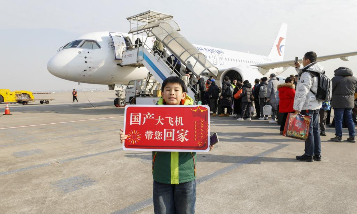 A child poses for photos with a C919 passenger aircraft at Shanghai Hongqiao International Airport in Shanghai, east China, Jan 26, 2024. Photo:Xinhua