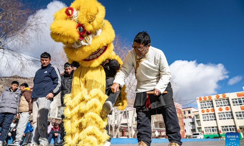 Tengpa Anye (R) instructs students to perform lion dance at a primary school in Xobando Town of Lhorong County in Qamdo City, southwest China's Xizang Autonomous Region, Jan. 19, 2024.