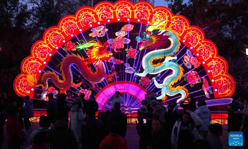 People enjoy the lantern show at the Baotu Spring Park in Jinan, capital city of east China's Shandong Province, Feb. 11, 2024. Over 40 light installations have been arranged here during the Spring Festival holiday. (Xinhua/Xu Suhui)