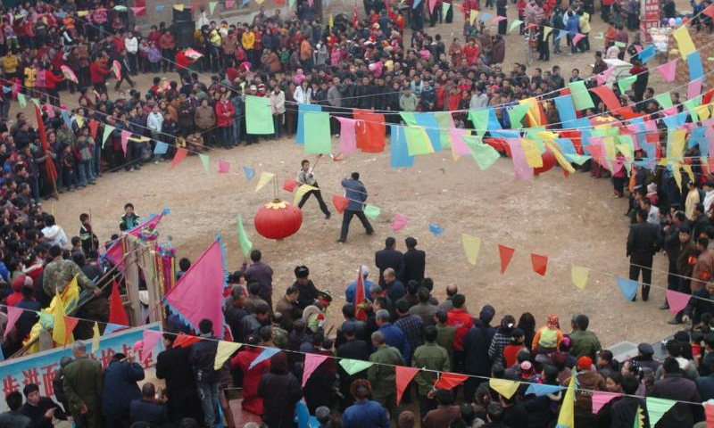 People watch a Shehuo folk performance in Dongyuan Village of Jingxing County, north China's Hebei Province before the Lantern Festival in 2007.