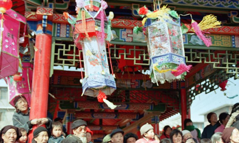 Farmers on the outskirts of Xi 'an City of northwest China's Shaanxi province watch a Shehuo folk performance during the Spring Festival in the late 1980s.
