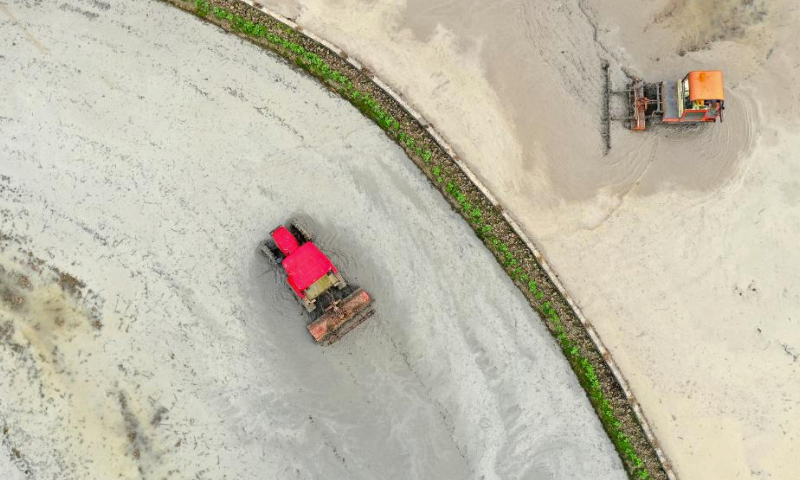 An aerial drone photo taken on Feb. 19, 2024 shows farmers operating machines to plough fields in Shichuan Village, Guan'ge Township, Guang'an City of southwest China's Sichuan Province. Farmers across China are busy with agricultural production as the day of Yushui (Rain Water), the second of the 24 solar terms in the Chinese lunar calendar, came on Monday this year. (Photo by Zhang Qifu/Xinhua)