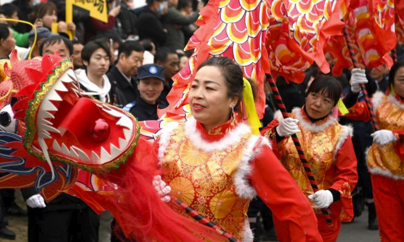Dragon dancers perform in a parade of folk customs in Huyi District, Xi'an of northwest China's Shaanxi Province, Feb. 18, 2024. (Xinhua/Liu Xiao)