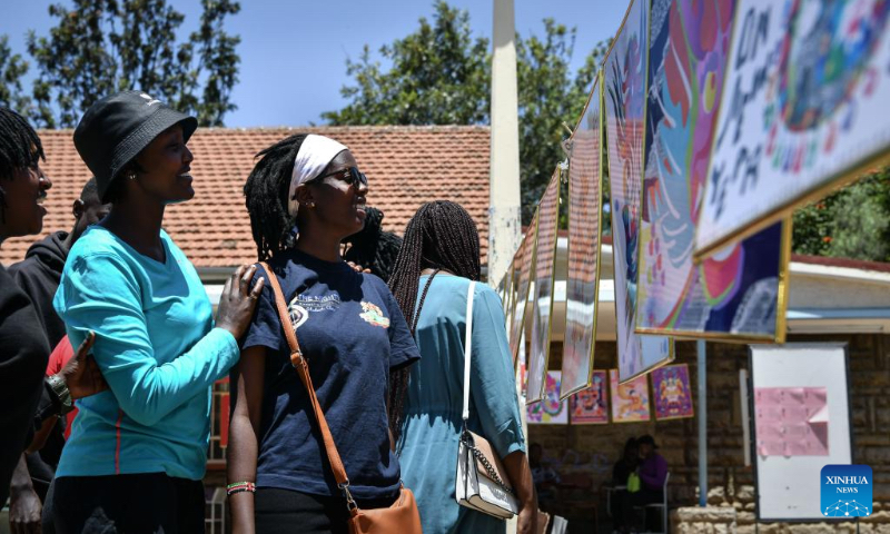 Students look at artworks during the Dragon Design Exhibition held at Kenyatta University in Nairobi, Kenya, Feb. 15, 2024. The day-long event showcasing different aspects of the Chinese dragon was held Thursday at Kenyatta University, Kenya's second oldest public university. (Xinhua/Han Xu)