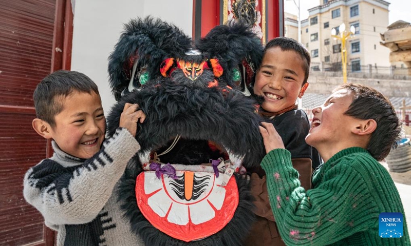 Children have fun with a lion dance prop at a primary school in Xobando Town of Lhorong County in Qamdo City, southwest China's Xizang Autonomous Region, Jan. 19, 2024. (Photo by Tenzin Nyida/Xinhua)