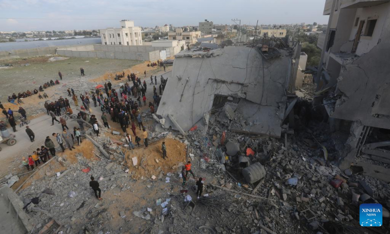 People check the rubble of a building destroyed in an Israeli air strike in the southern Gaza Strip city of Rafah, on Feb. 16, 2024. Palestinian medical sources told Xinhua that at least 11 Palestinians were killed in Israeli airstrikes on Rafah, Gaza's southernmost city on Friday. (Photo by Khaled Omar/Xinhua)