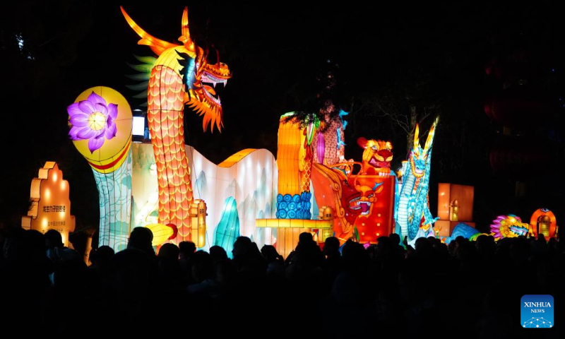 People enjoy the lantern show at the Baotu Spring Park in Jinan, capital city of east China's Shandong Province, Feb. 11, 2024. Over 40 light installations have been arranged here during the Spring Festival holiday. (Xinhua/Xu Suhui)