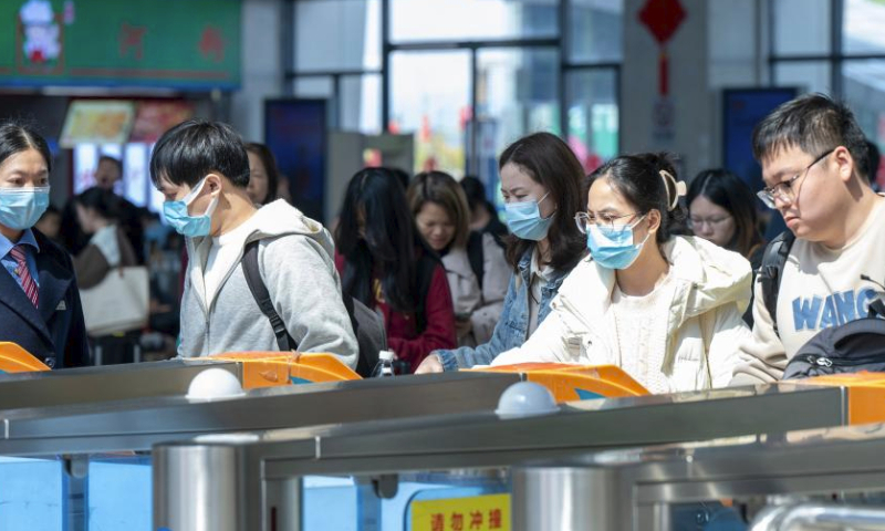 Travelers prepare to get on a train at Wuzhou South Railway Station in Wuzhou, south China's Guangxi Zhuang Autonomous Region, Feb. 16, 2024. China witnessed an increase of passenger trips as this year's Spring Festival holiday is coming to an end. (Photo by He Huawen/Xinhua)