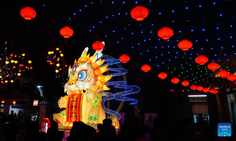 People enjoy the lantern show at the Baotu Spring Park in Jinan, capital city of east China's Shandong Province, Feb. 11, 2024. Over 40 light installations have been arranged here during the Spring Festival holiday. (Xinhua/Xu Suhui)